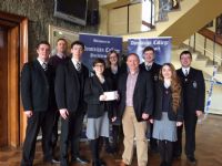 Teacher Ian Hynds and senior prefects present Aodh O'Loan with a cheque for SFR.